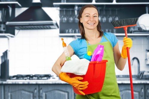 Professional oven cleaning team following safety procedures in a kitchen